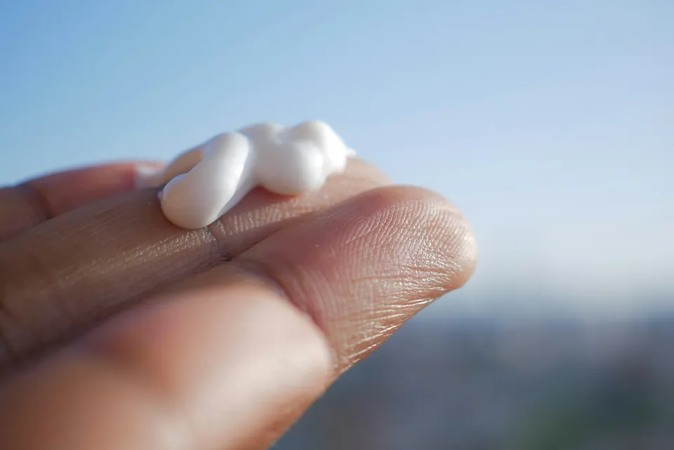 Moisturiser on fingers, dry skin care